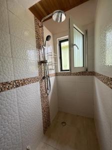 ein Bad mit einer Dusche und einem Fenster in der Unterkunft Emron Homelodge in Accra