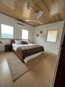 a bedroom with a large bed with a wooden ceiling at Emron Homelodge in Accra