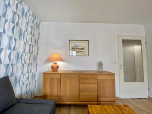 una sala de estar con una lámpara en una cómoda de madera en Le Beaugency Near Paris & Disneyland, en Champs-Sur-Marne