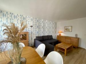 a living room with a couch and a table at Le Beaugency Near Paris & Disneyland in Champs-Sur-Marne