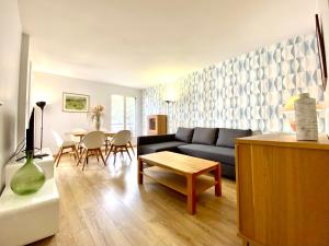 a living room with a blue couch and a table at Le Beaugency Near Paris & Disneyland in Champs-Sur-Marne