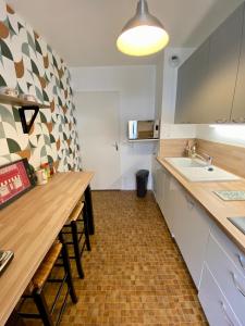 a kitchen with a long counter and a sink at Le Beaugency Near Paris & Disneyland in Champs-Sur-Marne