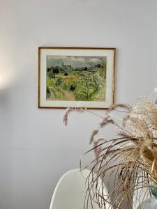 a picture hanging on a wall with a plant at Le Beaugency Near Paris & Disneyland in Champs-Sur-Marne