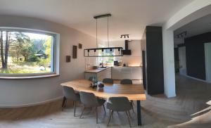 a kitchen and dining room with a wooden table and chairs at Przylesie Dom na Roztoczu in Ciotusza Stara