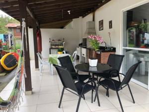 comedor con mesa negra y sillas en Linda Casa Piscina Natureza, en Florianópolis