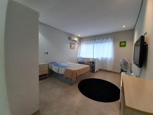 1 dormitorio con 1 cama y TV en Linda Casa Piscina Natureza, en Florianópolis