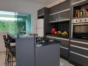 una cucina con piano cottura forno superiore accanto a un bancone di Linda Casa Piscina Natureza a Florianópolis