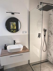 a bathroom with a sink and a shower at Przylesie Dom na Roztoczu 