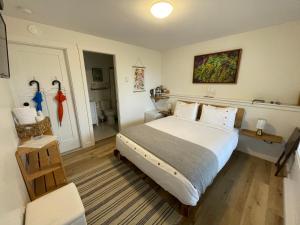 a bedroom with a large bed and a bathroom at Sounds of the Sea in Ucluelet