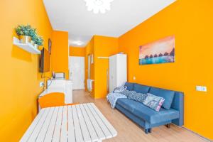 salon z niebieską kanapą i pomarańczową ścianą w obiekcie Studio a 199m de la playa los Locos w mieście Torrevieja