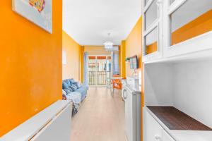 kuchnia z pomarańczowymi ścianami i salon w obiekcie Studio a 199m de la playa los Locos w mieście Torrevieja