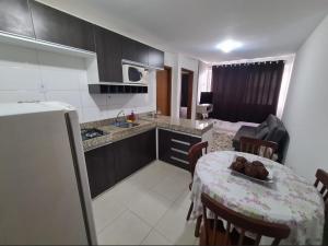 uma cozinha e uma sala de jantar com uma mesa num quarto em Apt encantador: piscina, academia, tela proteção em Taguatinga