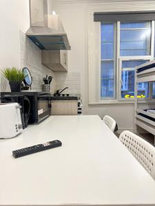 a kitchen with a counter with a remote control on it at Flat 6 in Croydon