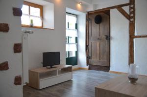 ein Wohnzimmer mit einem TV und einer Tür in der Unterkunft Ferienwohnung Stübchen in Salmtal