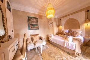 sypialnia z dużym łóżkiem i żyrandolem w obiekcie Riad 7 Saints w Marakeszu