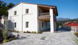 a white house with a balcony and a patio at Sette Fiori Luxury Apartments in Miane Premaor