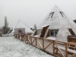 a group of yurt homes with snow on the ground at Cabañas Verde Pirámide in Ñilque