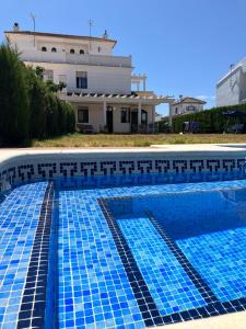 una piscina azul con un edificio de fondo en Holiday house with private pool, Costa de la Luz, en El Portil