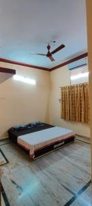 Cama en habitación con ventilador de techo en Sangeeta's Homestay, en Jagdalpur