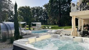 - un bain à remous dans une cour avec des chaises et une piscine dans l'établissement Château du Beugnon, à La Fosse-de-Tigné