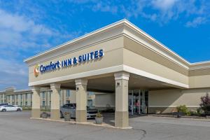 a court inn suites building with a car dealership at Comfort Inn & Suites in Triadelphia