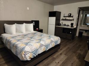 a bedroom with a large bed and a refrigerator at Studio 6 Sacramento, CA Natomas in Sacramento