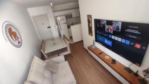 a living room with a large flat screen tv at Apartamento Novinho Aeroporto JF in Juiz de Fora