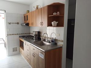 uma pequena cozinha com pia e fogão em Casa Laureles - San Joaquín em Medellín