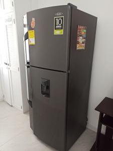 um frigorífico preto está sentado numa sala em Casa Laureles - San Joaquín em Medellín