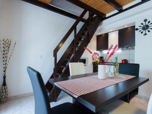 stół jadalny z krzesłami i schody w obiekcie Apartment Červar w Poreču