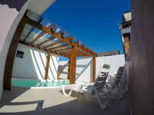 um pátio com 2 cadeiras e uma piscina em Residencial Viva Torres - Casas com 2 Dorms, Ar e Piscina Aquecida na Praia da Cal em Torres