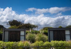 dos contenedores negros en un jardín con plantas en Quisquito Lodge & Spa - Punta de Lobos - Tina 24 Hrs, en Pichilemu