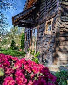 una casa con flores rosas delante de ella en Од А до Ш, en TrÅ¡iÄ‡