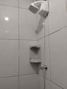 a shower in a tiled bathroom with a hose at Simples e Aconchegante in Mogi das Cruzes +10 photos