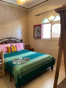 Surf & Salsa GuestHouse في أغادير: غرفة نوم بسرير ونافذة