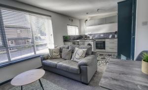 a living room with a couch and a table at #2 Limes by DerBnB, Modern 1 Bedroom Apartment, Free Parking, WI-FI & Netflix Near Royal Derby Hospital in Derby