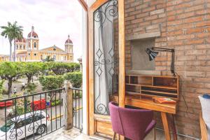 a balcony with a desk and a view of a building at Selina Granada in Granada