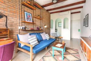 グラナダにあるSelina Granadaの青いソファとレンガの壁が備わるリビングルーム