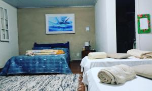 a room with two beds and two rugs at Pousada do Tie - Rio Preto MG in São José do Rio Preto