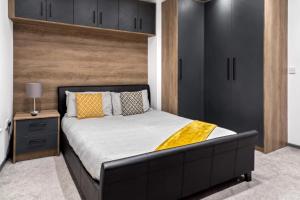a bedroom with a large bed with a black headboard at Cowgate Luxury Apartments in Peterborough