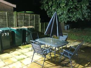 a table and chairs with an umbrella on a patio at Beautiful 3 bedroom house! in Coventry