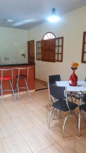 Cette chambre comprend une table, des chaises et un comptoir. dans l'établissement Sítio Alazão, à Moeda