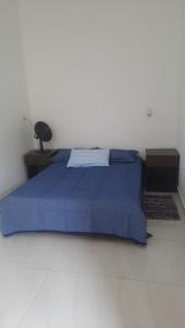 a bedroom with a blue bed and a lamp on a table at Sítio Alazão in Moeda