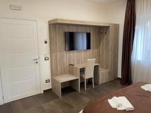 Zimmer mit einem Schreibtisch und einem TV an der Wand in der Unterkunft B&B La Villa Cittanova in Cittanova