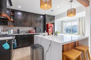 uma cozinha com um balcão branco e um frigorífico vermelho em Vacation Home I Big Backyard I 5min to SoFi em Inglewood