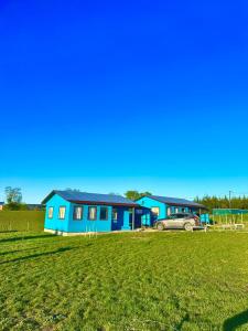 una casa blu con una macchina parcheggiata di fronte di Cabañas Alto las Torres a Los Ángeles