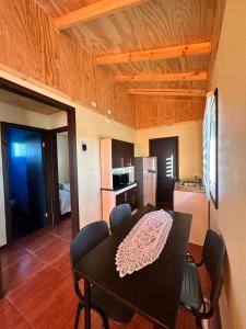 a kitchen and dining room with a table and chairs at Cabañas Alto las Torres in Los Ángeles