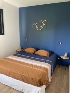 Schlafzimmer mit einem Bett mit blauer Wand in der Unterkunft Appartement Cocooning entre lacs et montagnes in Saint-Alban