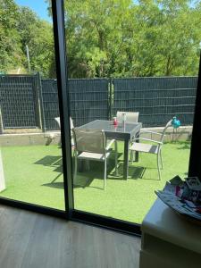 a patio with a table and chairs in a yard at Appartement Cocooning entre lacs et montagnes in Saint-Alban