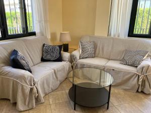 sala de estar con 2 sofás y mesa de cristal en Holiday house with private pool, Costa de la Luz, en El Portil